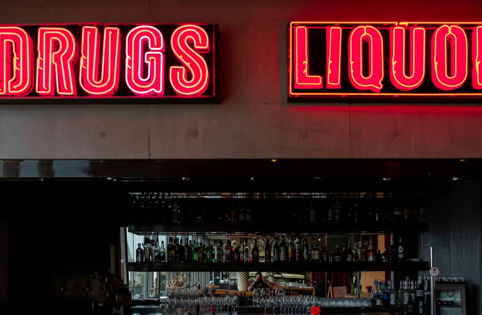 Eine Bar im Hintergrund und im Vordergrund die Schriftzüge drugs and liquors.